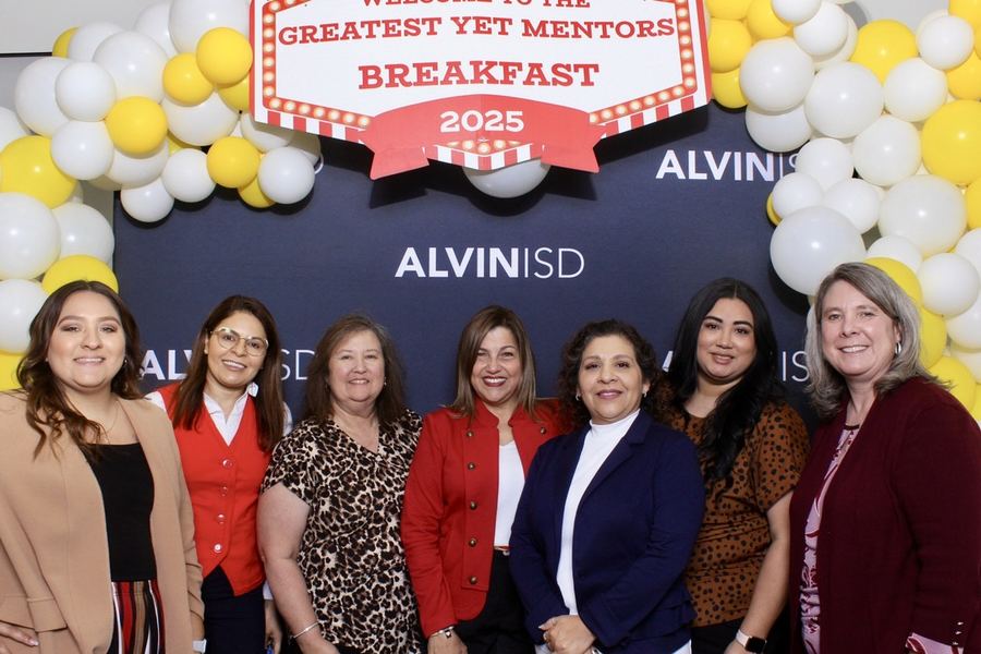 A corporate mentoring breakfast, with a group of guests photographed against a branded balloon backdrop.